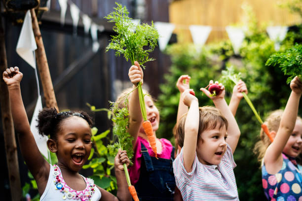 Kids in a vegetable garden with carrot